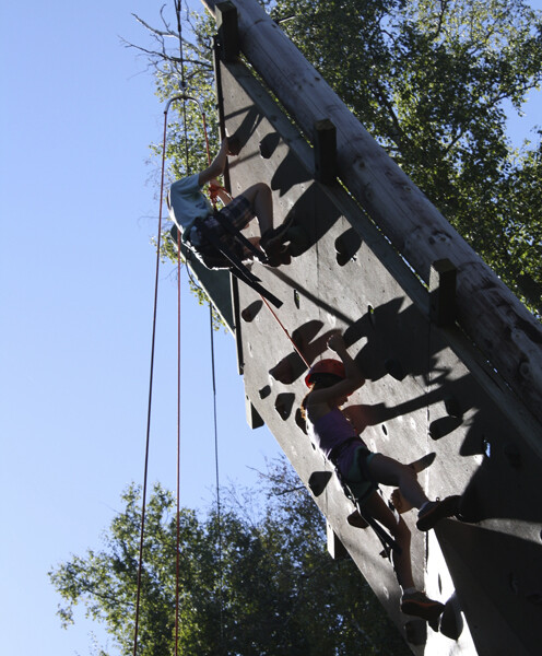 students climbing rock wall