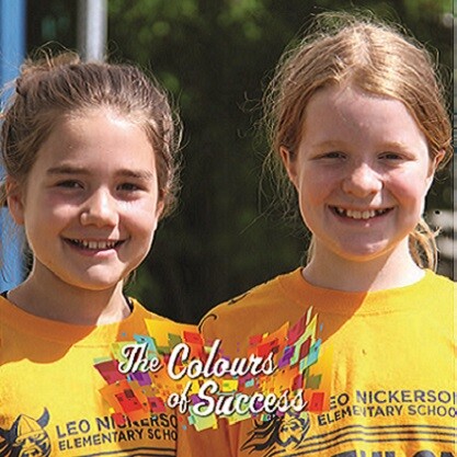 two female students in school shirts with "The colours of success" in text on photo