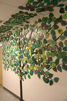 school hallway wall with art pieces that create a tree